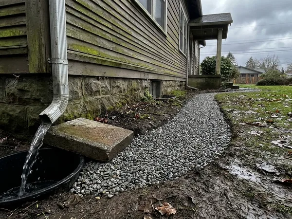 Extended downspout into a below-grade drain line after fix